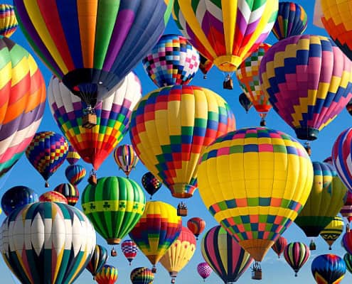 Cluster of colorful hot air balloons in sky.
